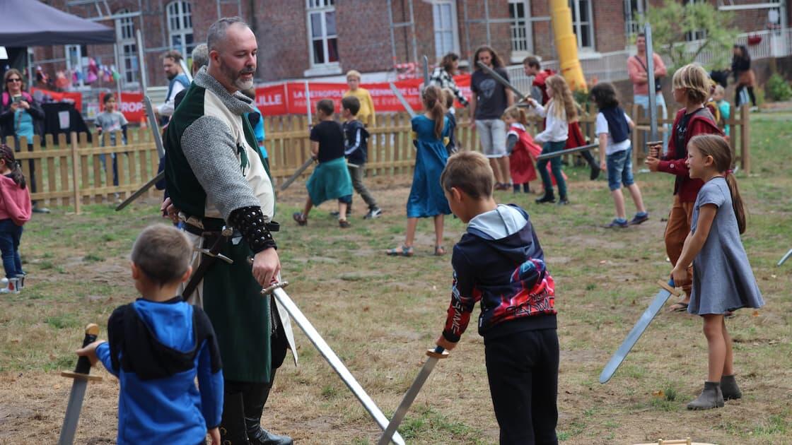 Homme en costume médiéval qui joue avec des enfants 